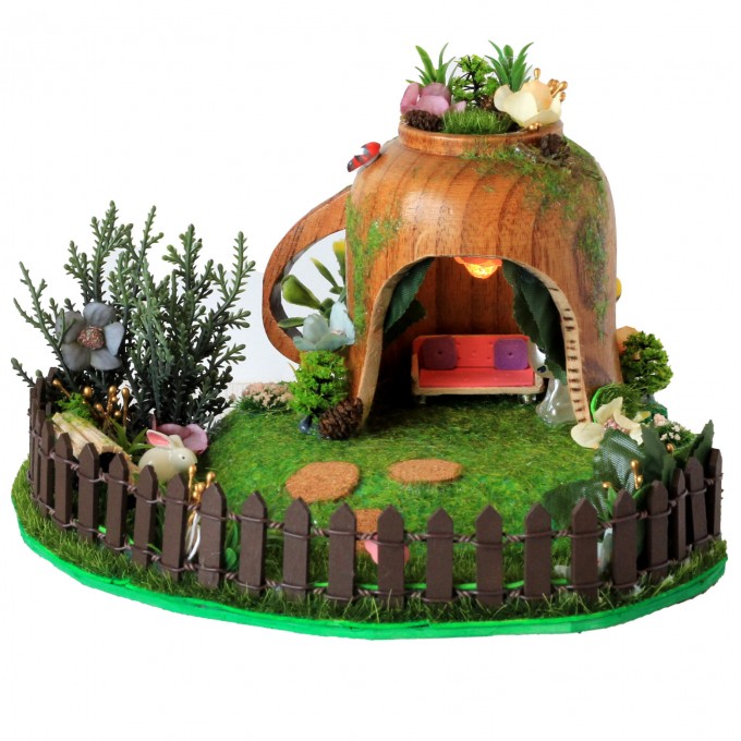 Miniature fairy garden house in tea cup room inside 