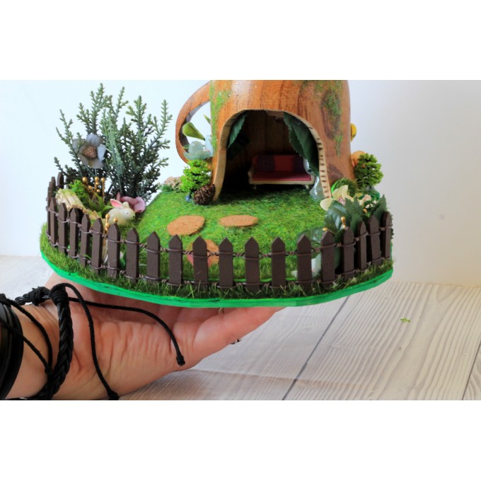 Miniature fairy garden house in tea cup room inside 