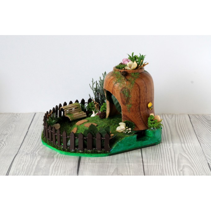 Miniature fairy garden house in tea cup room inside 