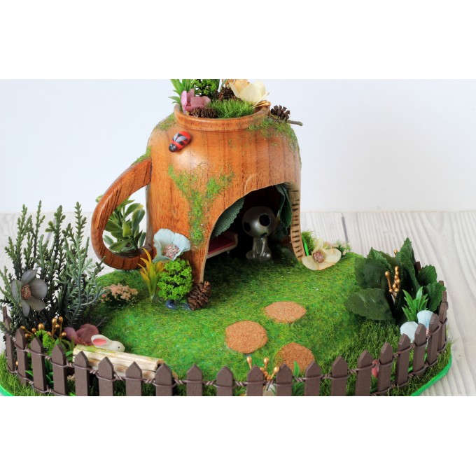 Miniature fairy garden house in tea cup room inside 