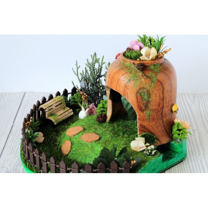 Miniature fairy garden house in tea cup room inside 