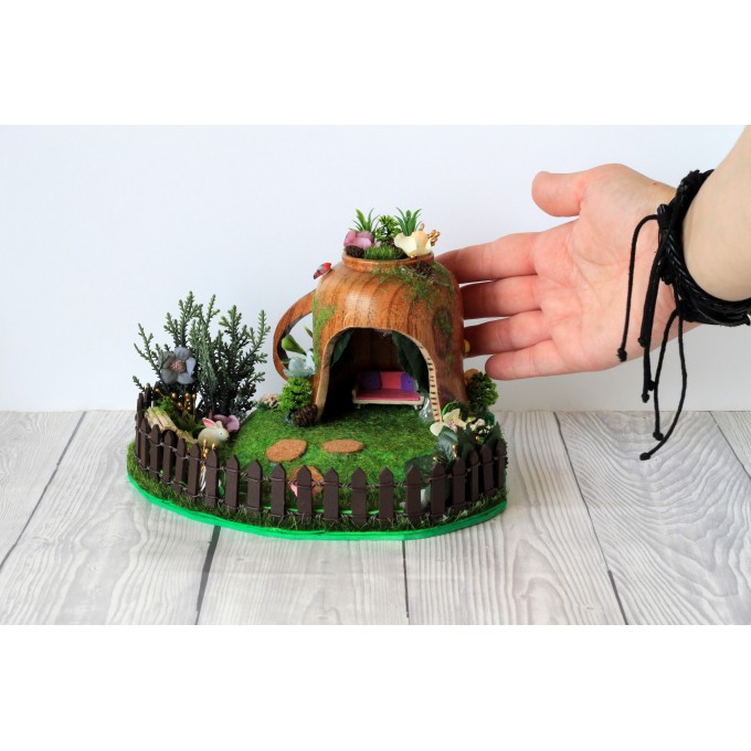 Miniature fairy garden house in tea cup room inside 