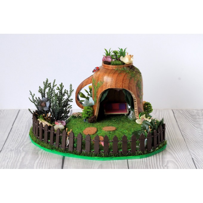 Miniature fairy garden house in tea cup room inside 