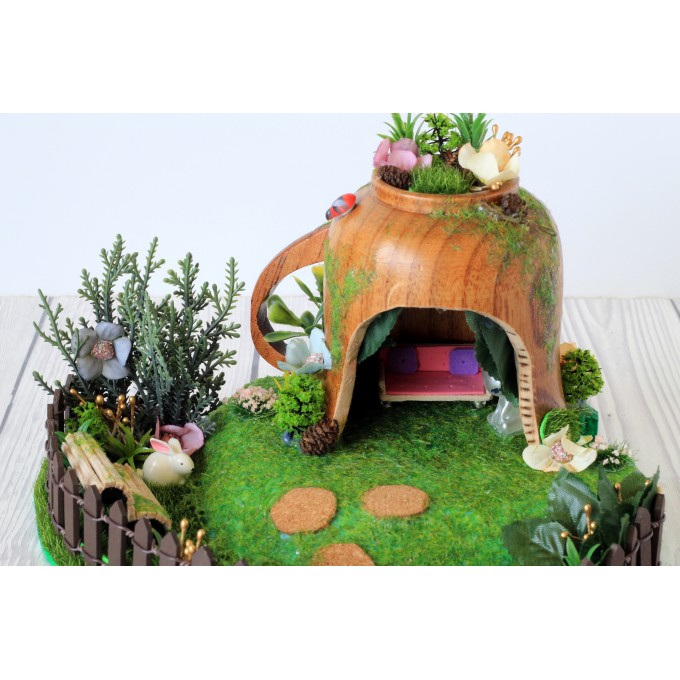 Miniature fairy garden house in tea cup room inside 